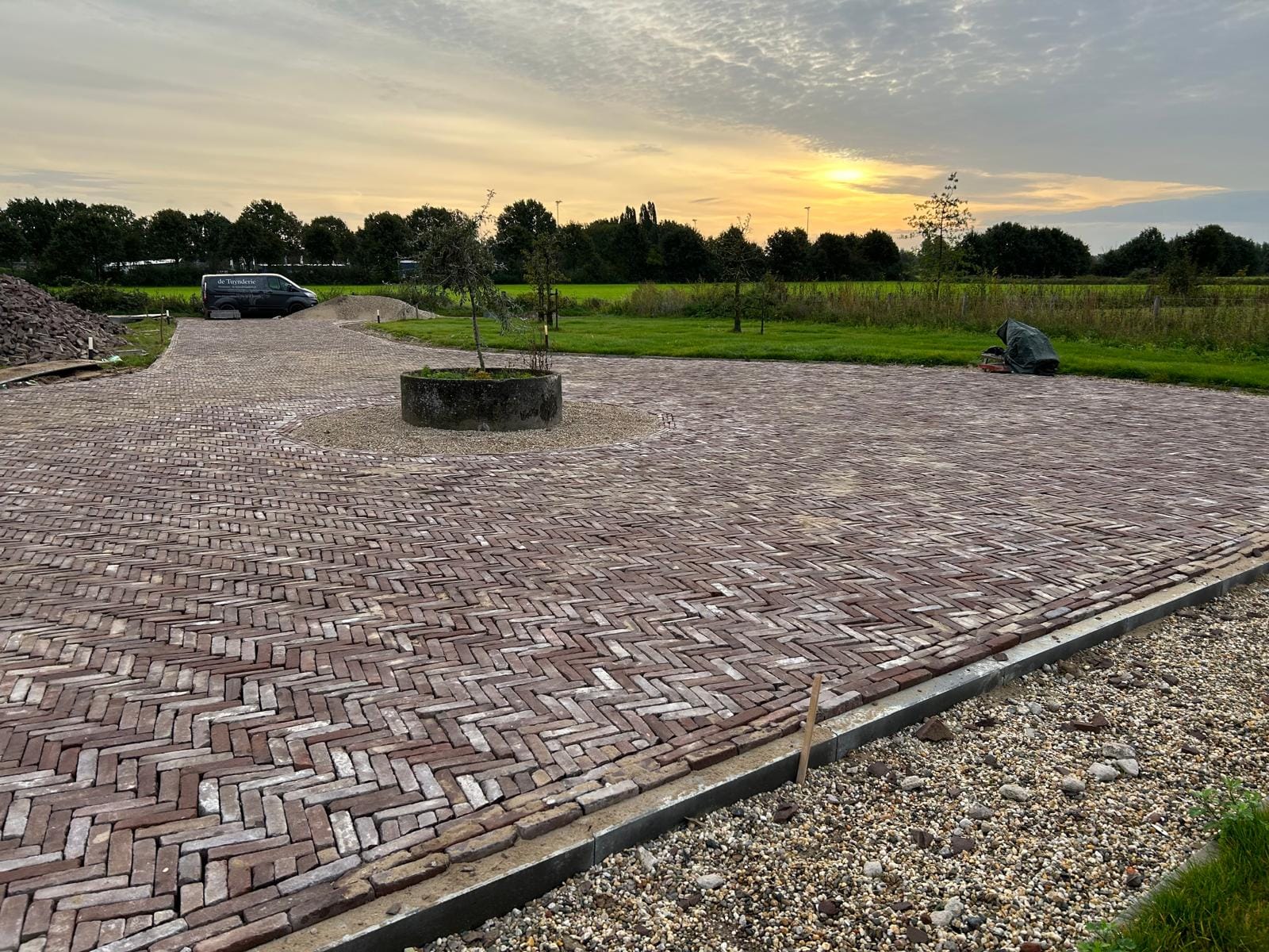 Klinkerbestrating aangelegd bij een karakteristieke woonboerderij, uitgevoerd door De Tuynderie.