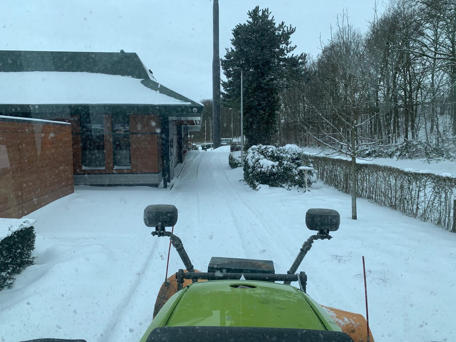 Sneeuwschuiven en strooien met een tractor in de McDrive van een restaurant van fastfoodketen McDonald's, uitgevoerd door De Tuynderie.