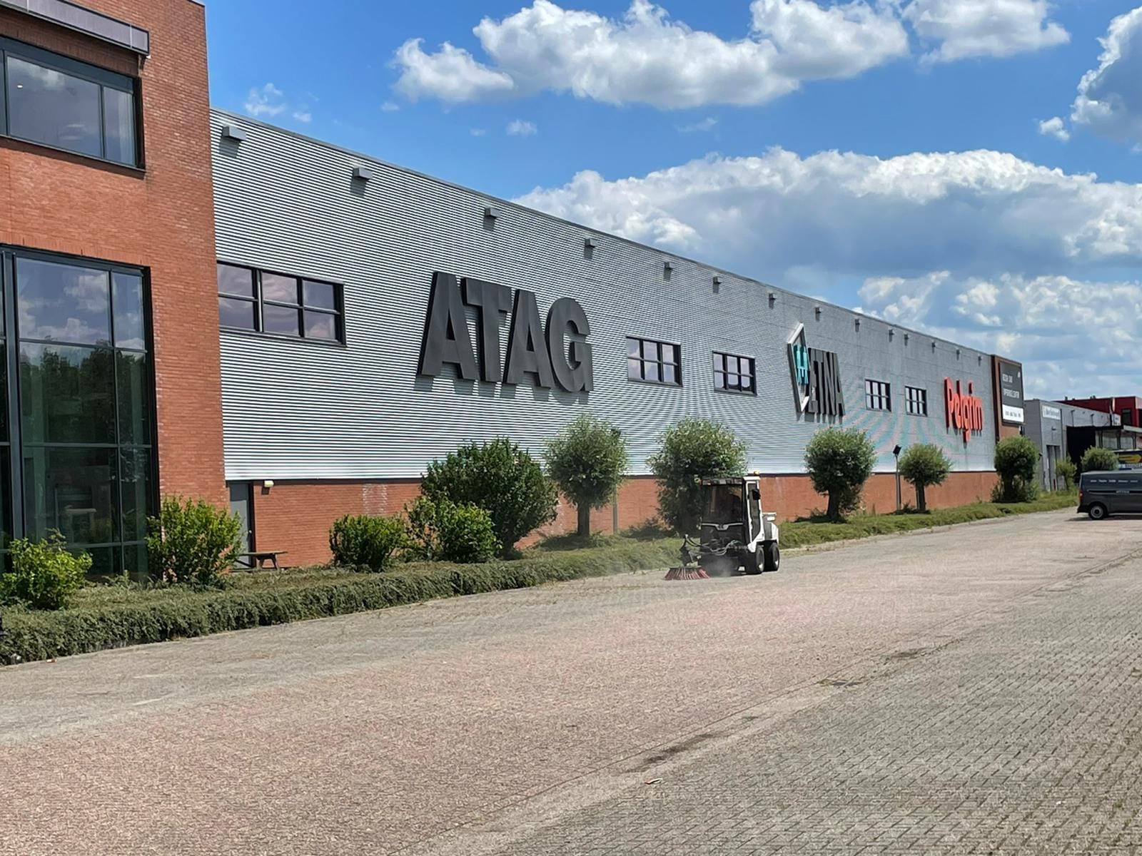 Veegmachine in actie na snoeiwerkzaamheden op een groot bedrijventerrein van een toonaangevende fabrikant van keukenapparatuur, uitgevoerd door De Tuynderie.